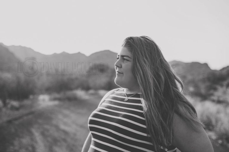 black and white sunset photo of young girl striped dress straight hair looking off to horizon with danielle jacqueline in desoto county ms during senior portrait session