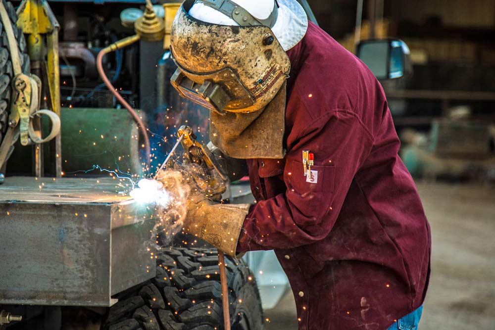 sparks flying on back of custom truck for welder with tank and sheet metal big tires professional services local business photographer danielle jacqueline american apparel on site