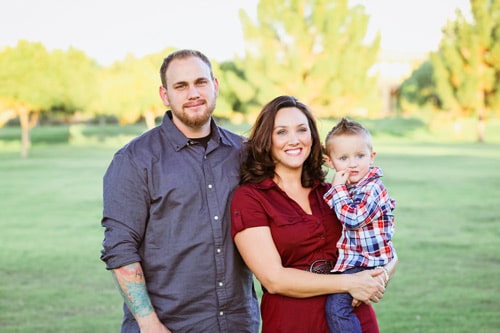 married couple burgandy attire with little boy grass green backdrop all smiles husband enjoying himself enough to give great review for danielle jacqueline photography located in olive branch ms