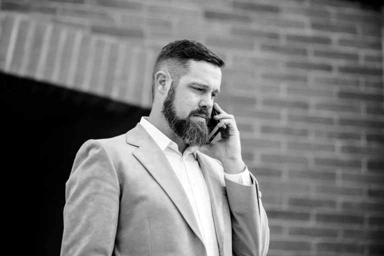 black and white photo brick tunnel background entrepreneur talking on cell phone serious pose for lifestyle headshot images by danielle jacqueline photography in desoto county ms