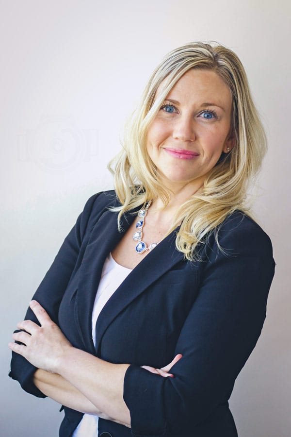 blonde business woman in formal attire at photography studio in olive branch ms plain background for website by danielle jacqueline headshots