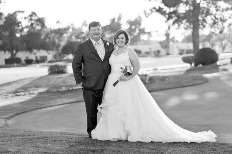 husband and wife celebrating their wedding day during outdoor ceremony at resort holding flowers happy as can be by danielle jacqueline photography in desoto county ms