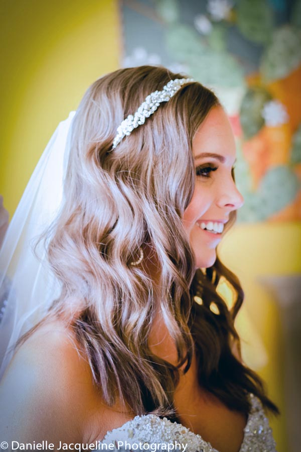 hair and makeup of bride to be in dress before ceremony begins in private room with wedding photographer danielle jacqueline out of olive branch ms