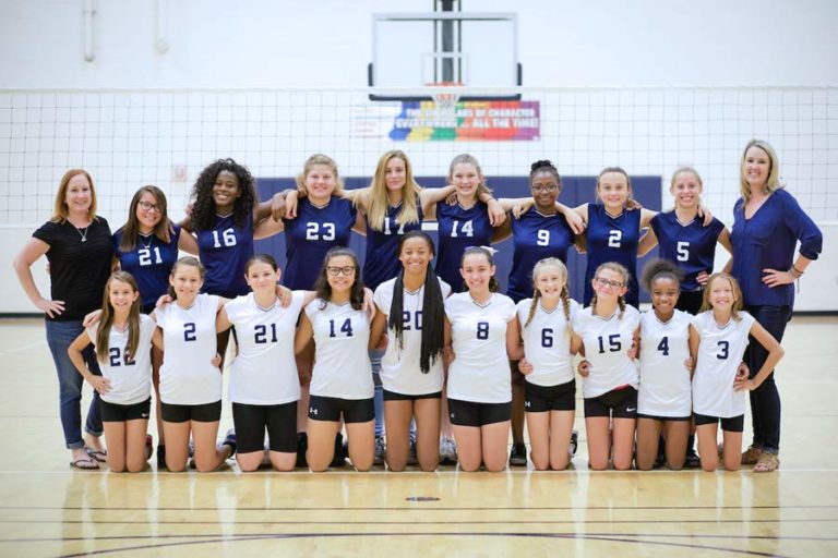 team sports photographer in olive branch ms captures middle school girls volleyball squad in municipal gym after school with basketball hoop in background for parents and students by danielle jacqueline