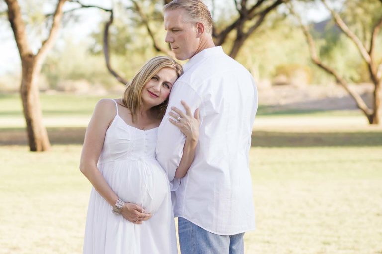 in my husband's arms maternity portraits by danielle jacqueline outdoors with expecting couple open field with trees in desoto county ms