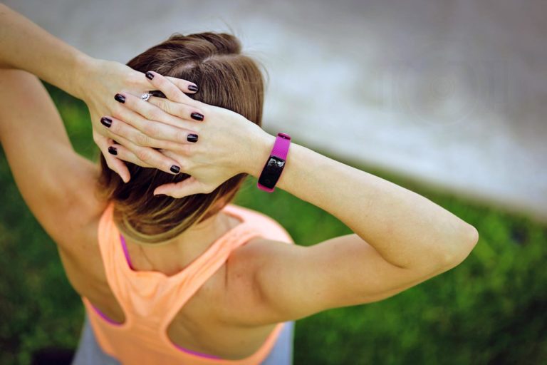 athletic woman with hands on head after running competition in olive branch ms grass and sidewalk out of focus in orange muscle shirt black fingernails by danielle jacqueline photography