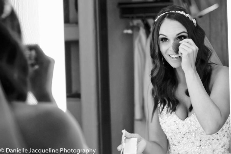 bride to be putting on makeup in bridal party suite before ceremony begins for personal wedding photographer session by danielle jacqueline in memphis tn