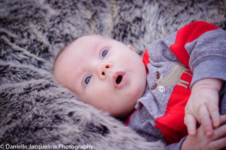 oh ahh mouth wide open baby boy laying on plush pillow thinking of the days when he can walk and talking after being born to parents in memphis tennessee captured by danielle jacqueline photography for picture ideas