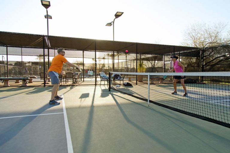 live action of tennis volley 1 on 1 matchup at dusk with net and court in full view of match caught by danielle jacqueline sports photographer in northern mississippi