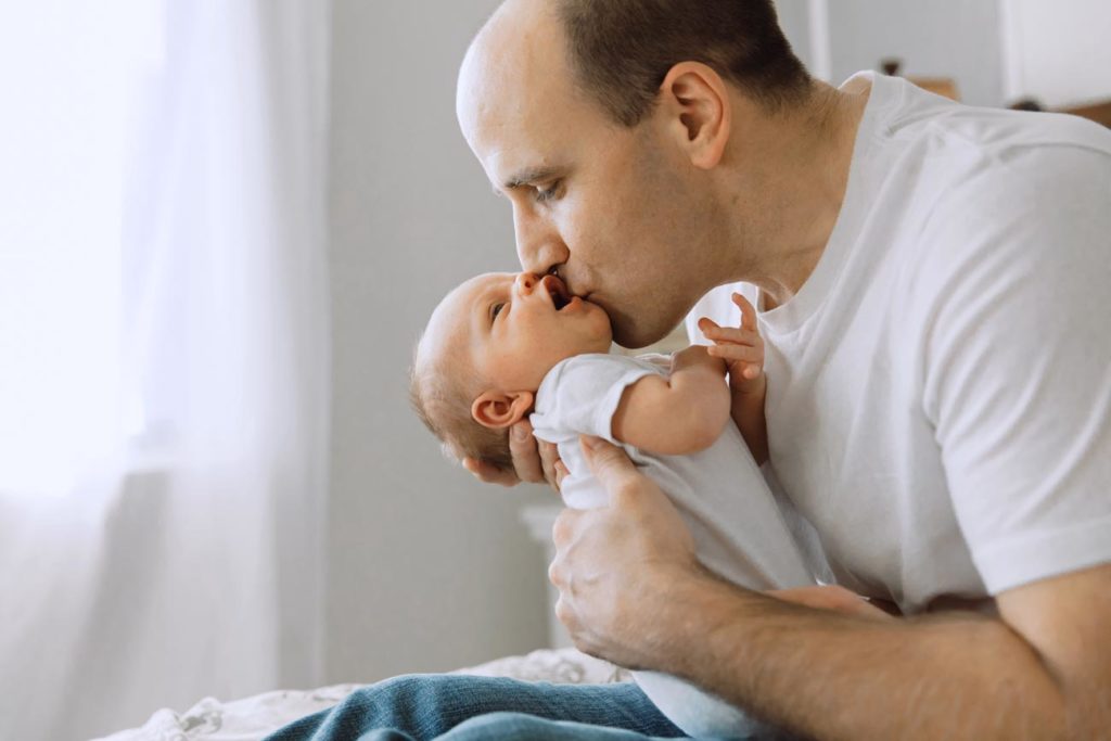 finally home baby boy seated by window after newborn baby photography session in memphis tennessee with danielle jacqueline