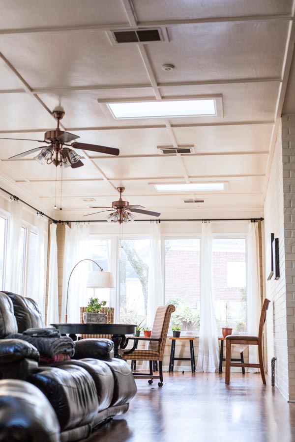 vertical image of photographer's studio in olive branch mississippi with leather couch and a few wooden chairs used for headshots and other indoor sessions with danielle jacqueline