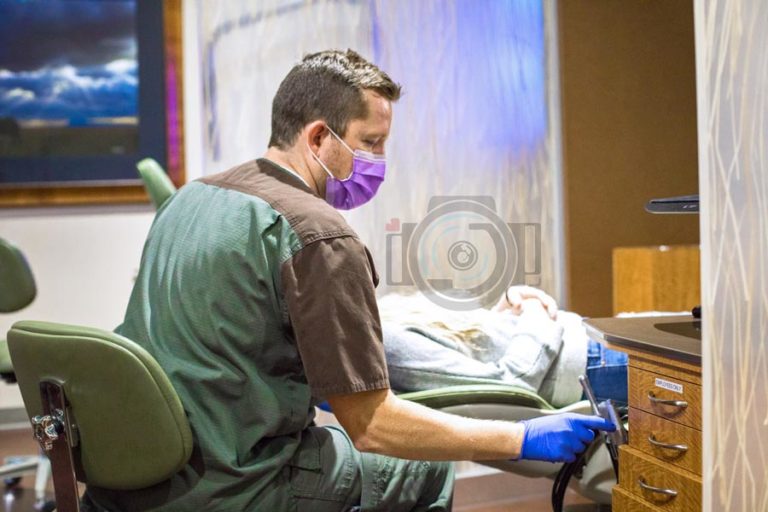 young dental hygienist wearing medical mask during procedure with pediatric patient during photo shoot with memphis photographer danielle jacqueline