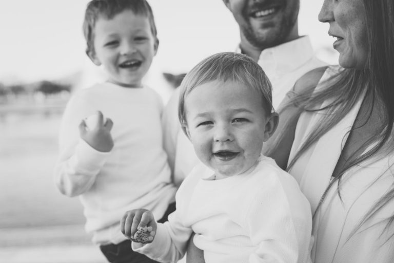 handsome young boys in parents arms during black and white photo session all smiles at mississippi state park by danielle jacqueline for families