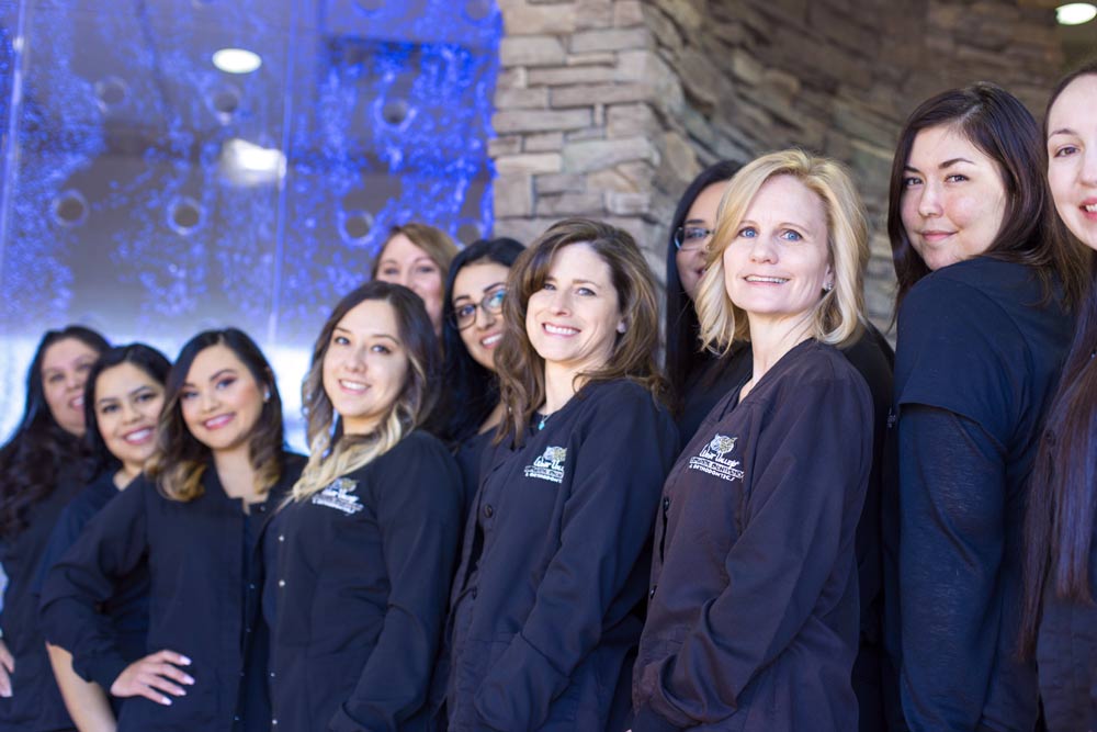 hero image of dentist office staff wearing matching scrubs looking left towards mississippi based danielle jacqueline photography's camera