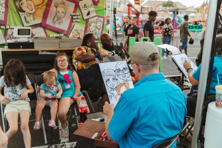 professional artist drawing kids and husband and wife faces at midsouth fair september 2022 at booth for money by danielle jacqueline photography in olive branch ms