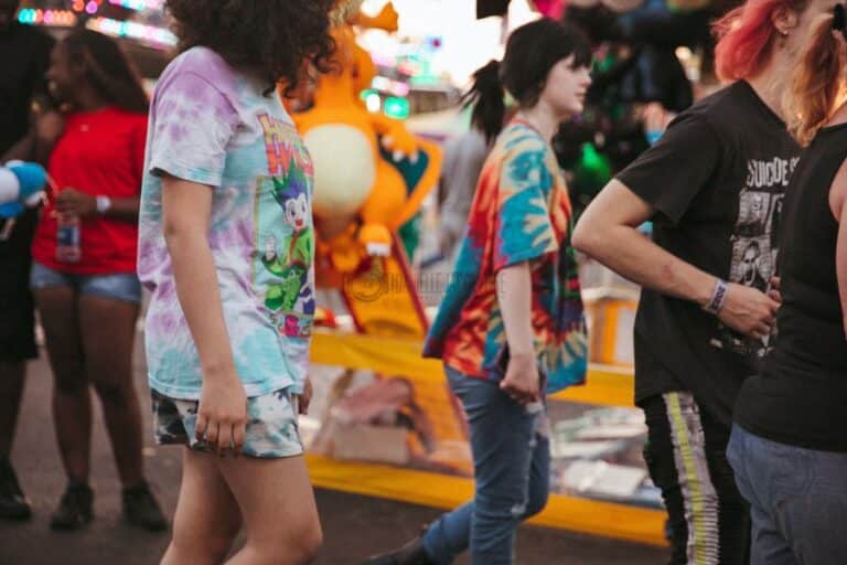 group of teen girls friends in tie dye shirts walking around fair enjoying rides, food and games with each other before sundown photography by danielle jacqueline memphis tn