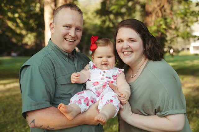 sweet natural pose of content mississippi parents with their one year old only child during family photo session with danielle jacqueline at private location near memphis tn