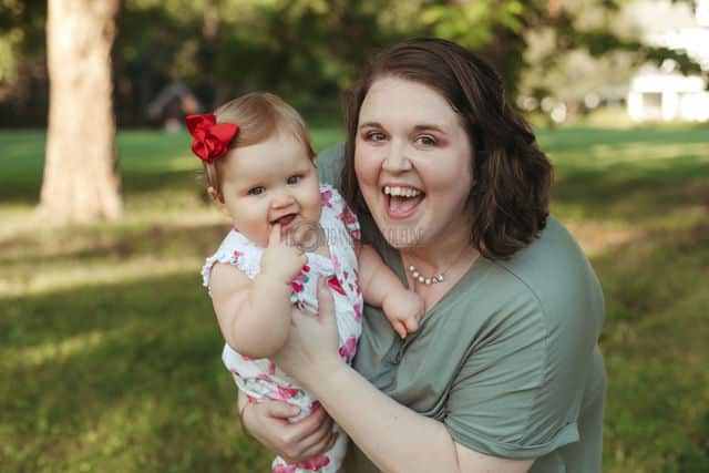 enthused mommy holding one year old daughter during birthday photo shoot with danielle jacqueline natural trees property olive branch mississippi