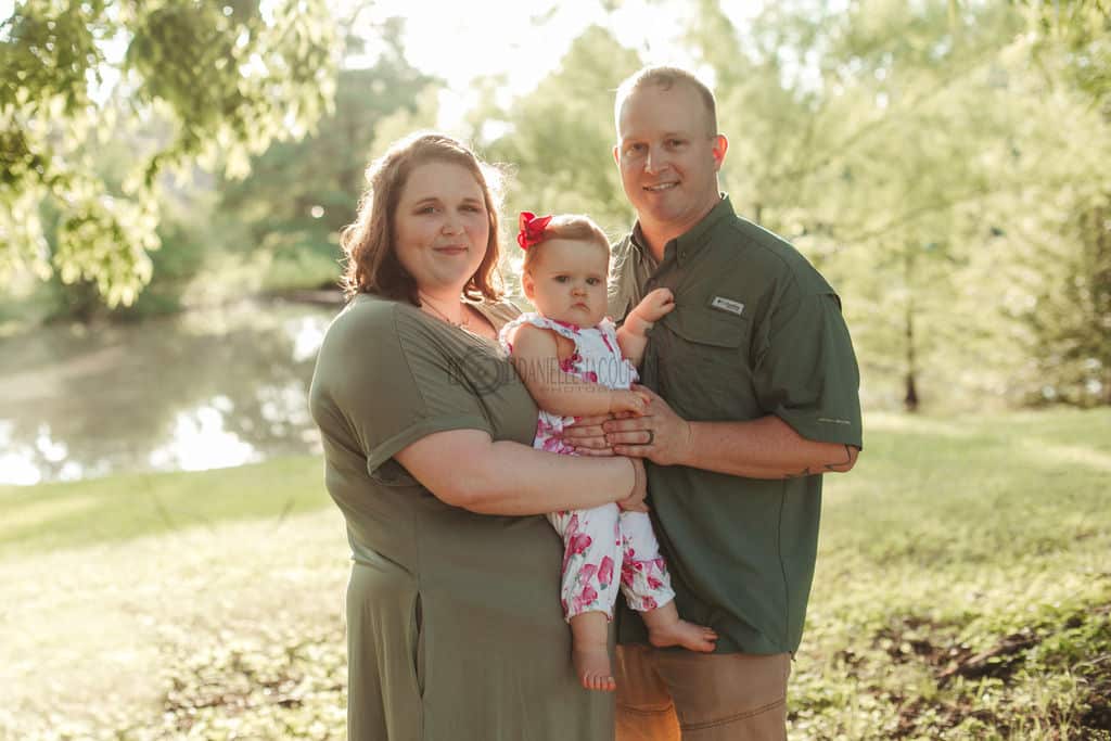 young family photo green theme forrest pond background mom dad parents with one year old celebrating birthday olive branch mississippi photo packages by danielle jacqueline