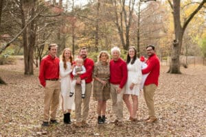 grandparents with grandchildren and kids outdoors in autumn leaves wearing white and red colors for family portraits with danielle jacqueline photography from olive branch ms