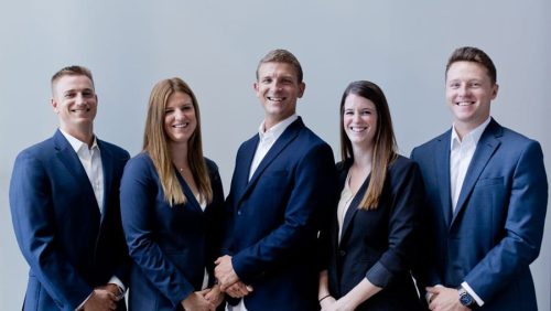 corporate photo of management team all wearing matching blue blazers during indoor session at studio for website by danielle jacqueline photographer near memphis tn